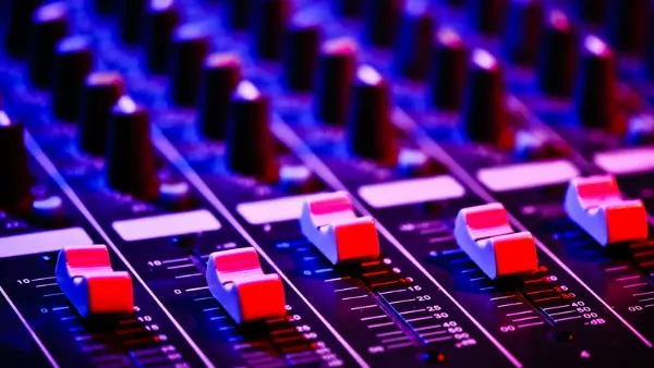 Hình nền DJ với bàn mix nhạc và ánh đèn sân khấu sôi động.